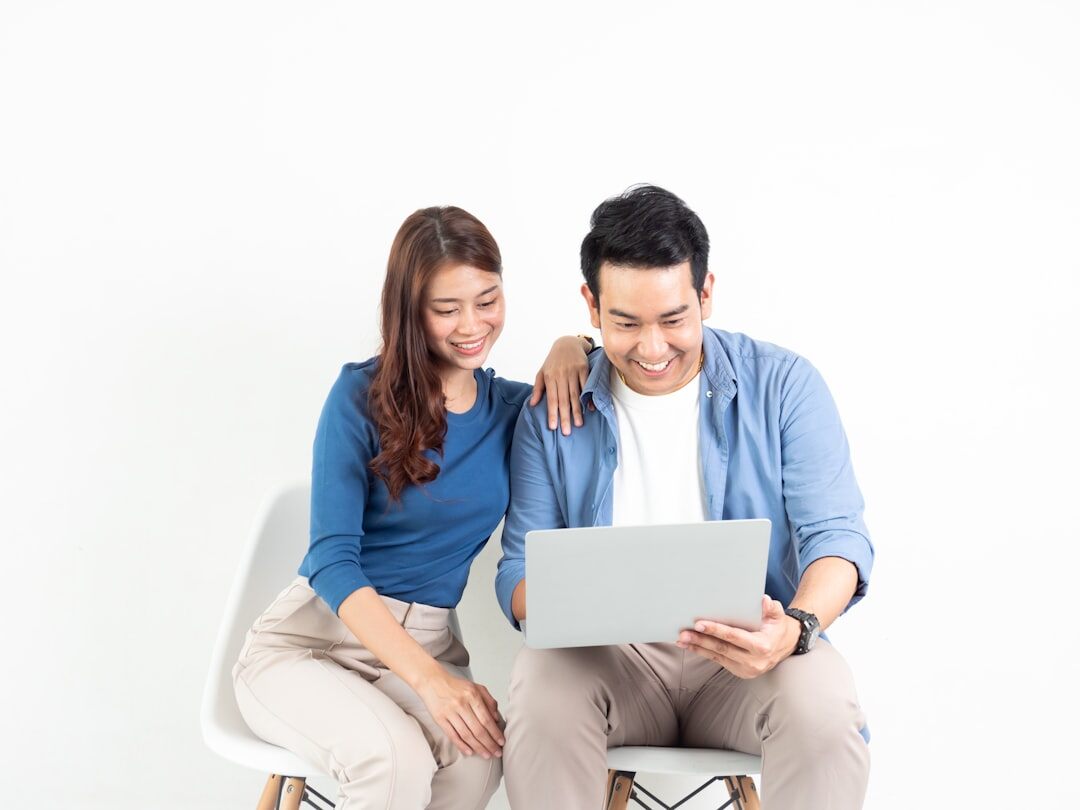 Two colleagues reviewing growth charts on a laptop at a wooden desk